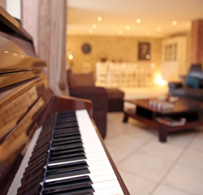 vue sur le piano et le salon d'un des gîtes du Domaine 3 Soleils